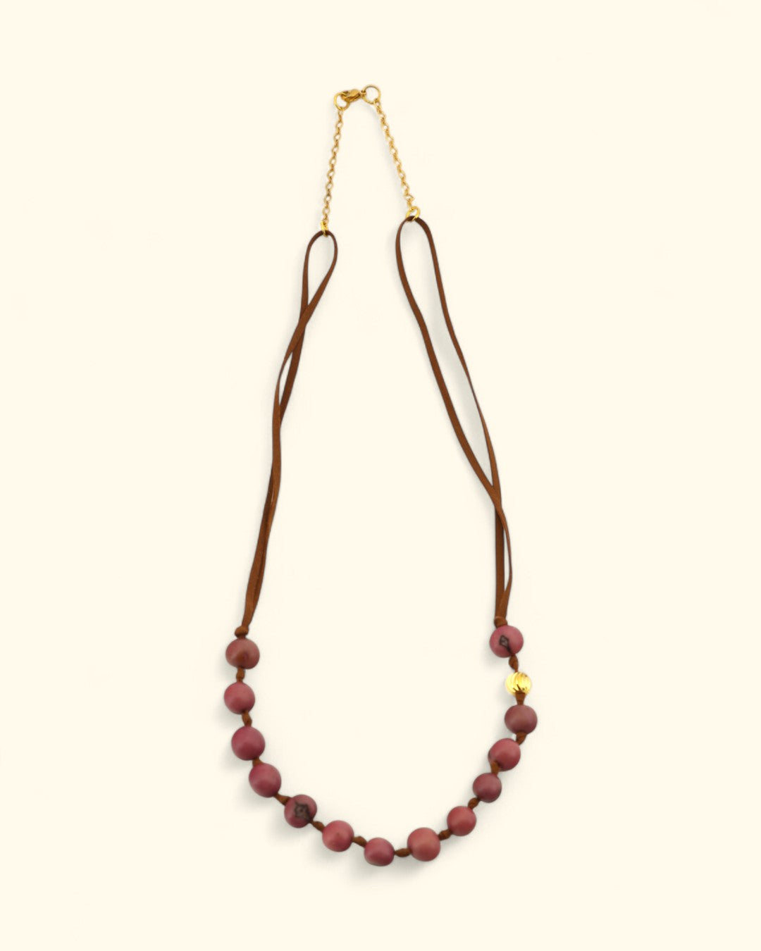 Necklace with burgundy beads and a gold chain on a white background