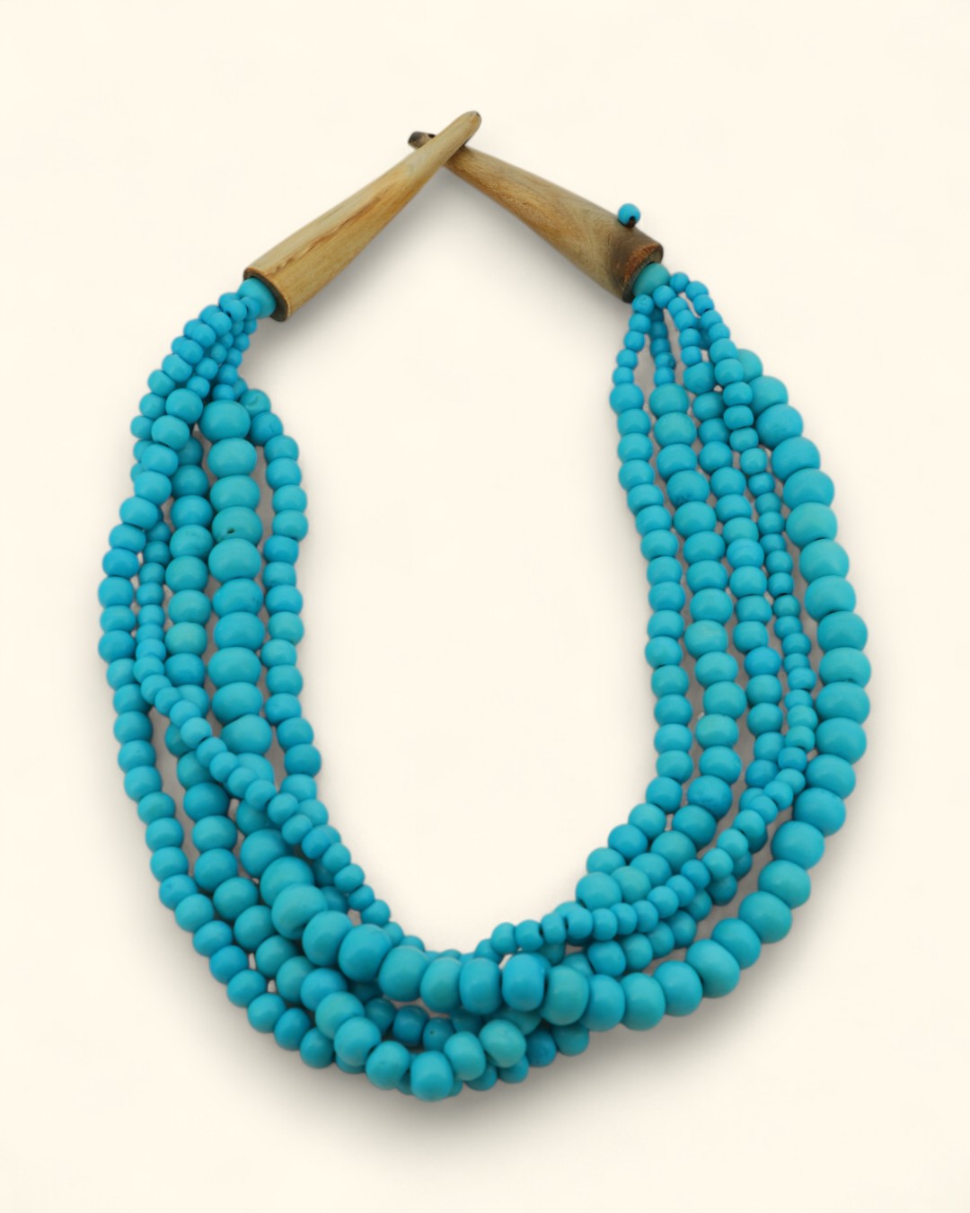 Turquoise beaded necklace with horn clasp on a white background