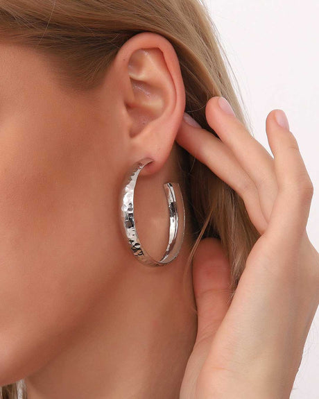 Large hammered silver hoop earring worn on ear