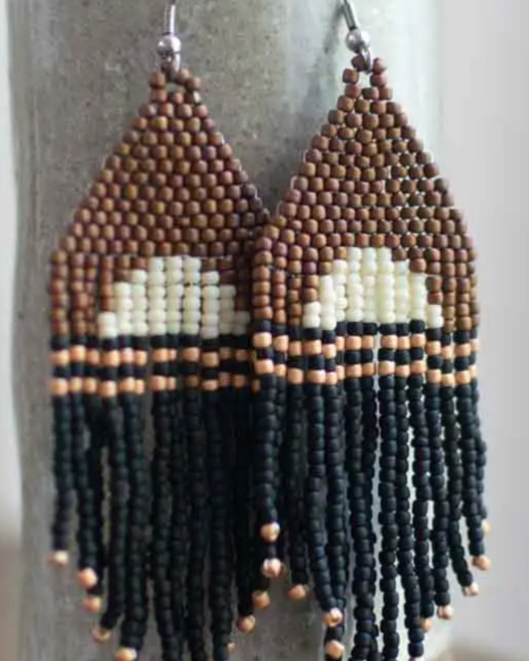 Beaded earrings with a geometric pattern on a neutral background