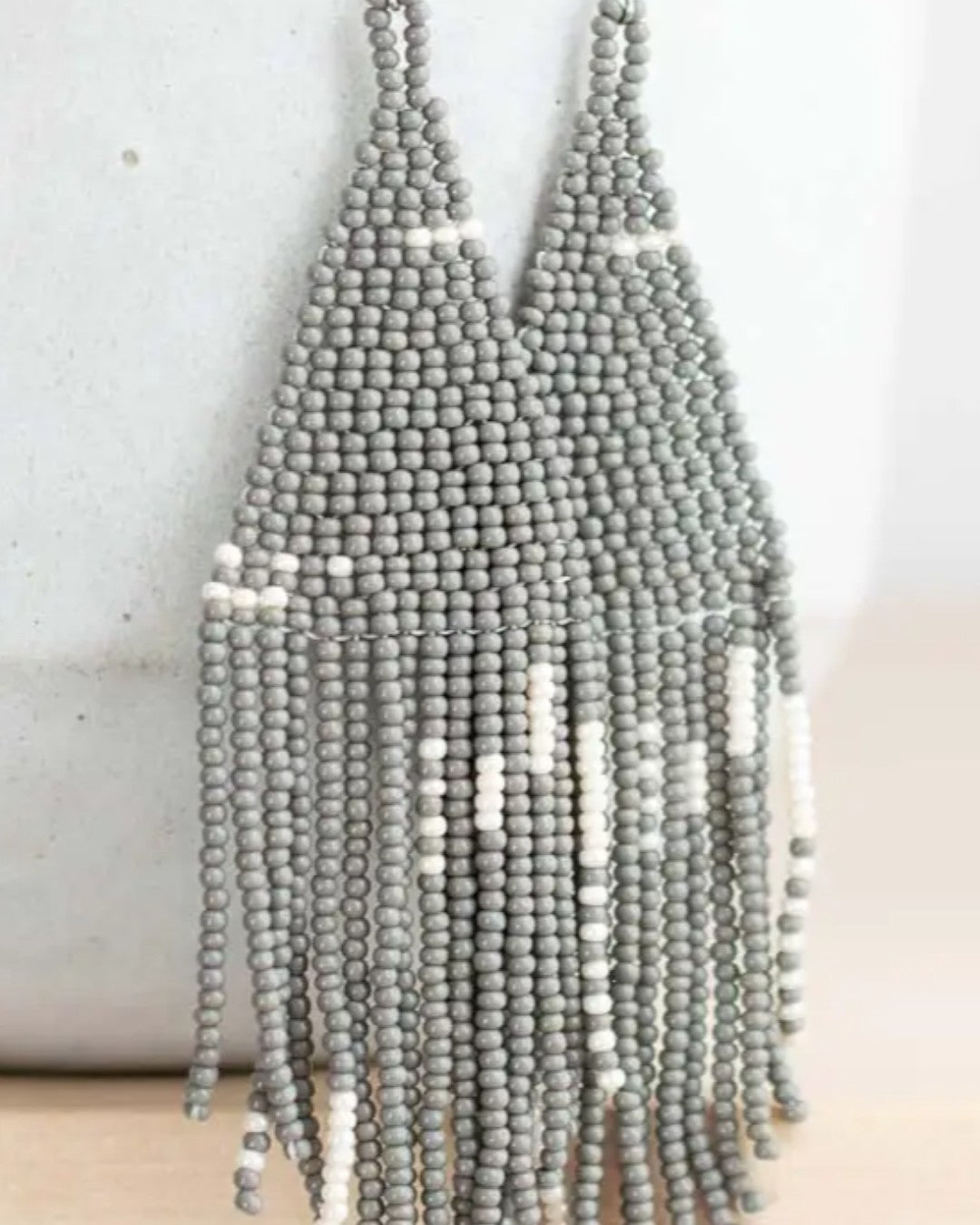 Gray beaded necklace on a light background