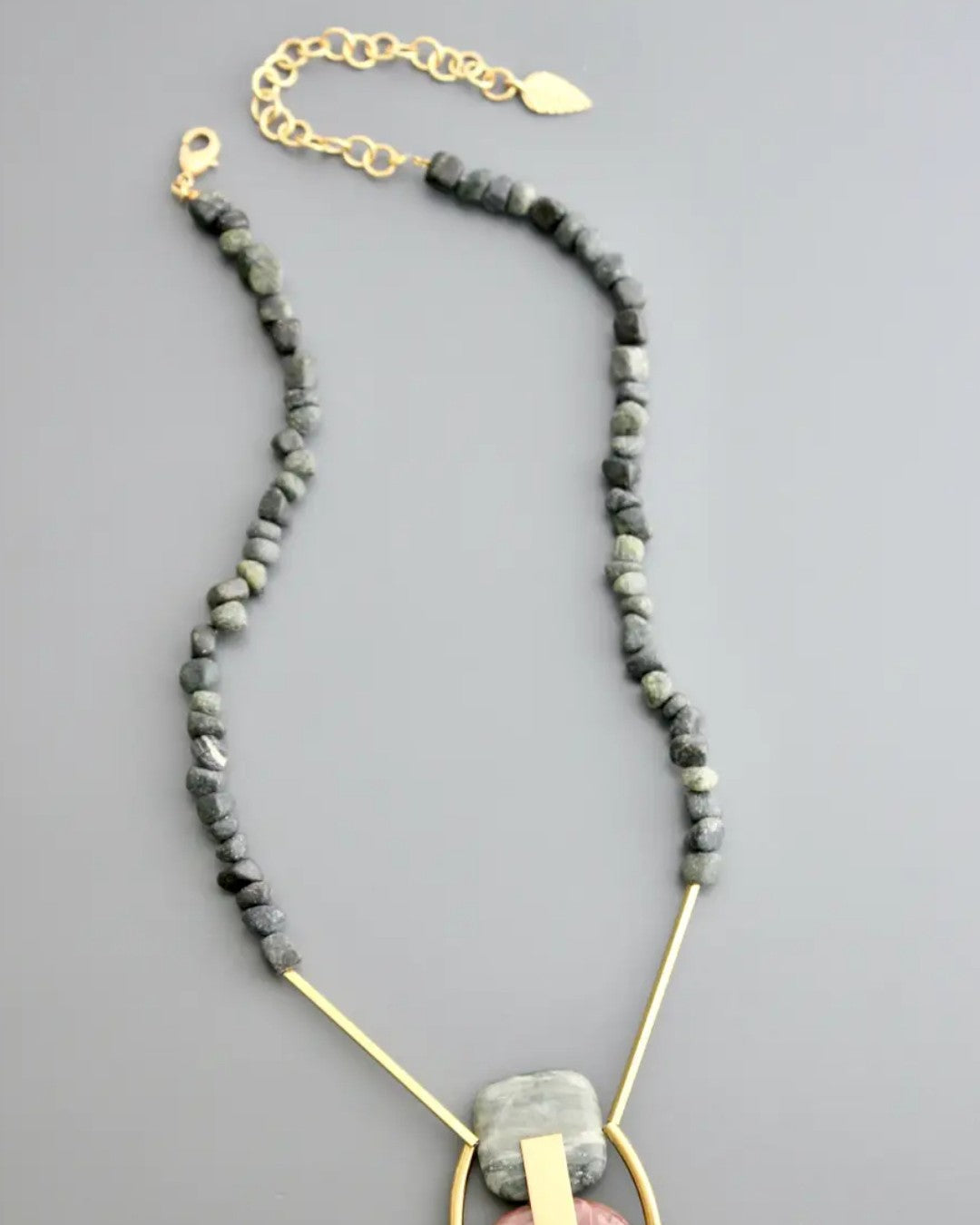 Pendant necklace with brass frame and natural stone beads