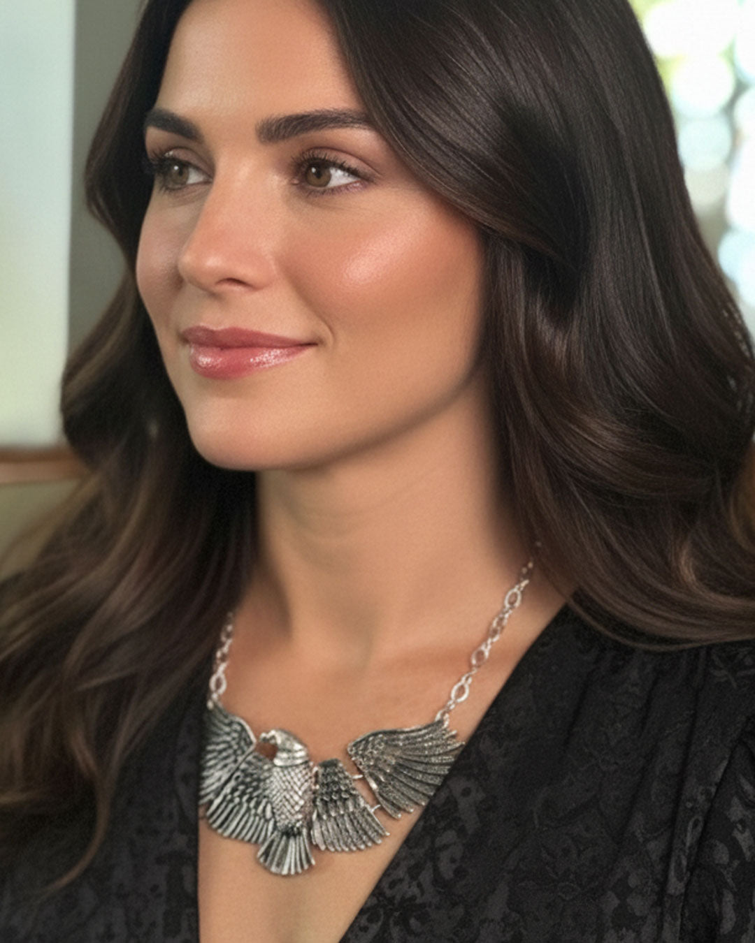 Woman wearing a silver necklace with an eagle design