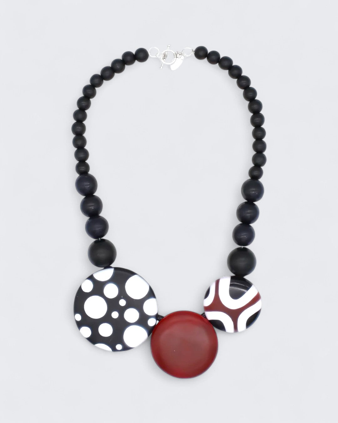 Statement necklace featuring polka dot, geometric, and solid resin pendants