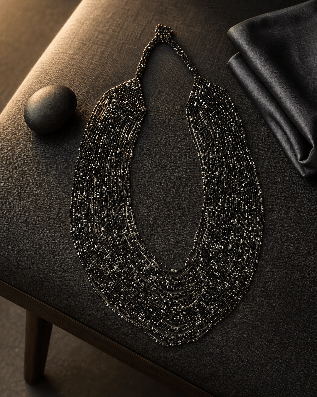 Black and grey multi-strand glass beaded necklace with rim lighting highlighting layered bead texture