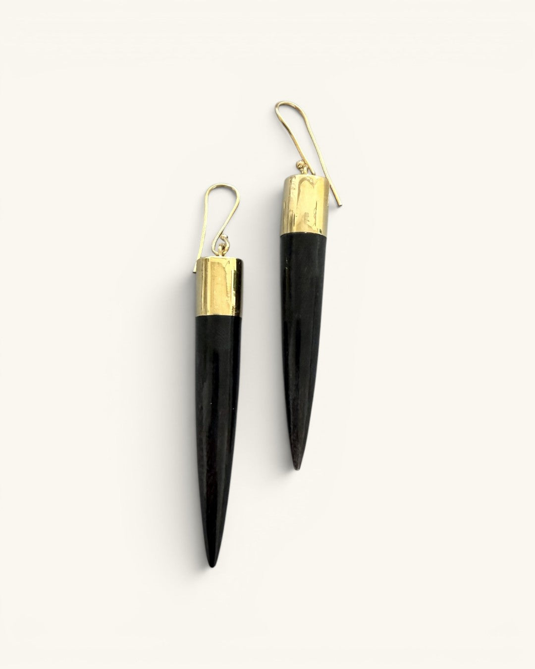 Kami black horn brass spike drop earrings pair on white background, front view showing gold wire hooks and brass caps above spikes