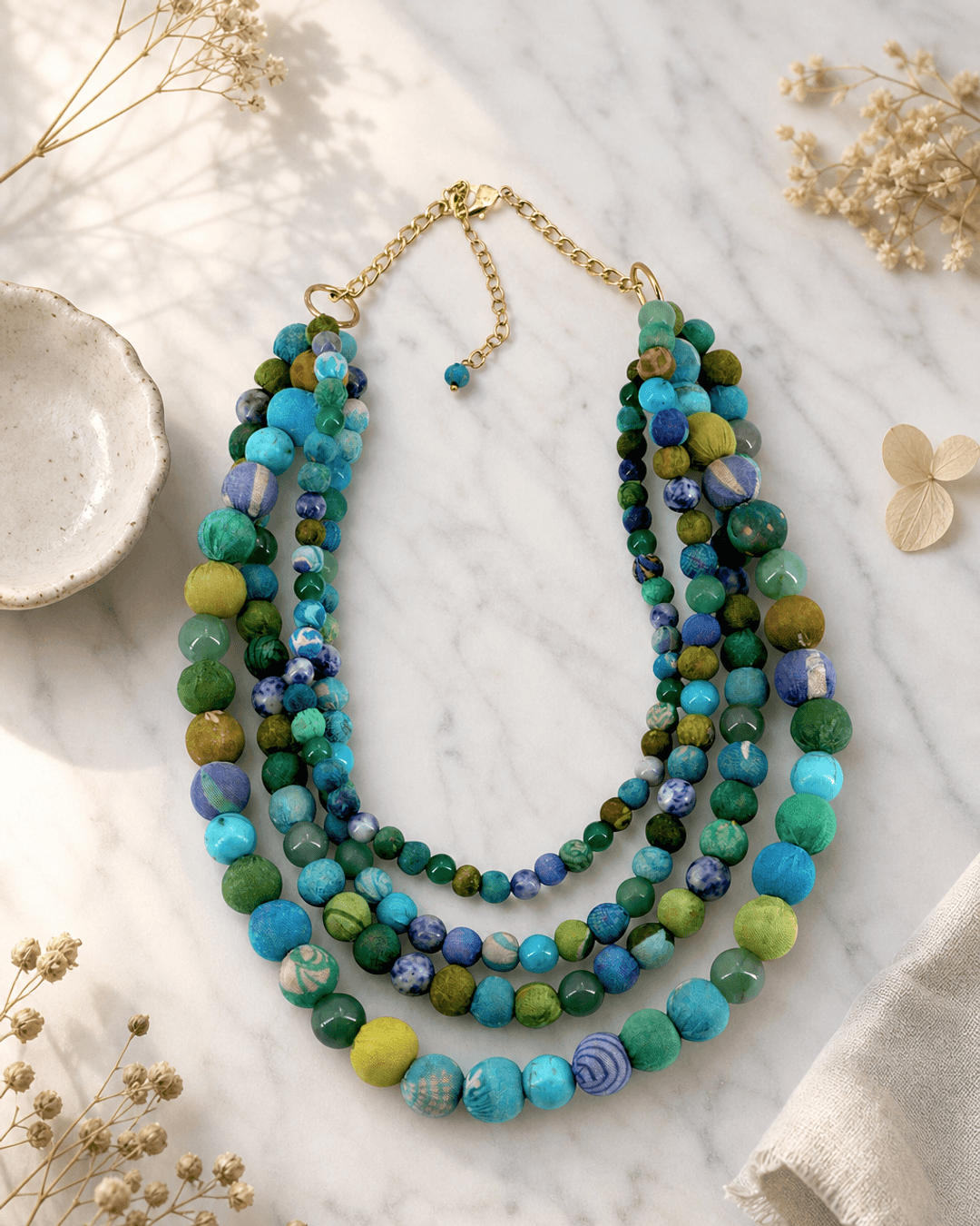 Blue-Green Kantha Bead Statement Necklace — necklaces, editorial marble lifestyle photo
