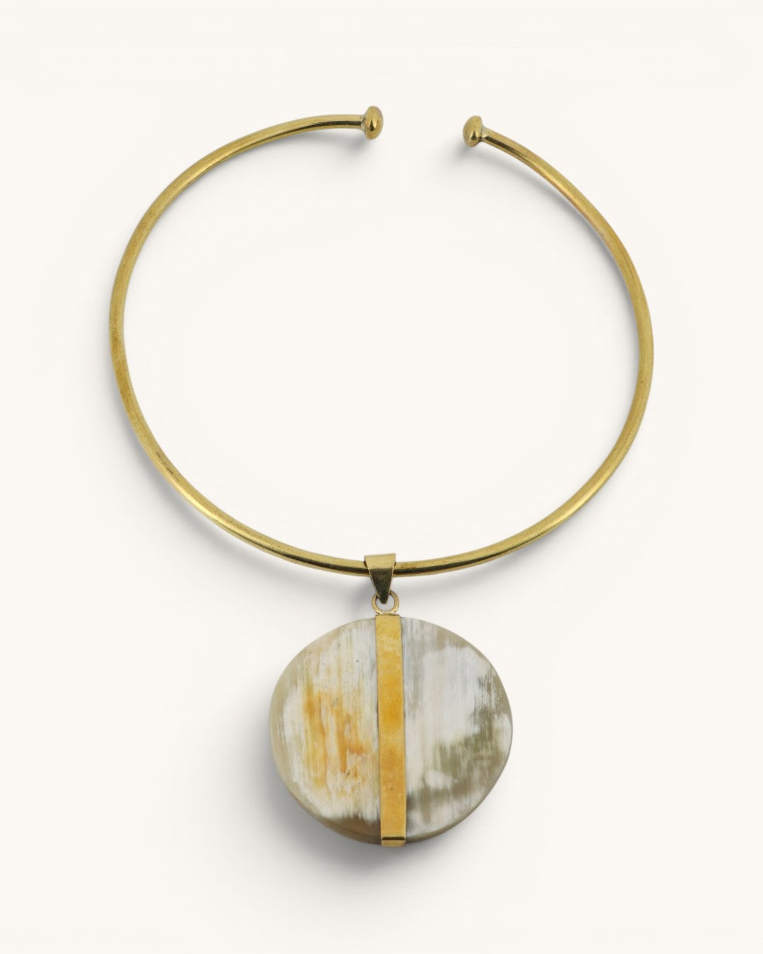 Brass collar choker necklace with round Ankole horn disc pendant and vertical brass bar accent, front view on white background