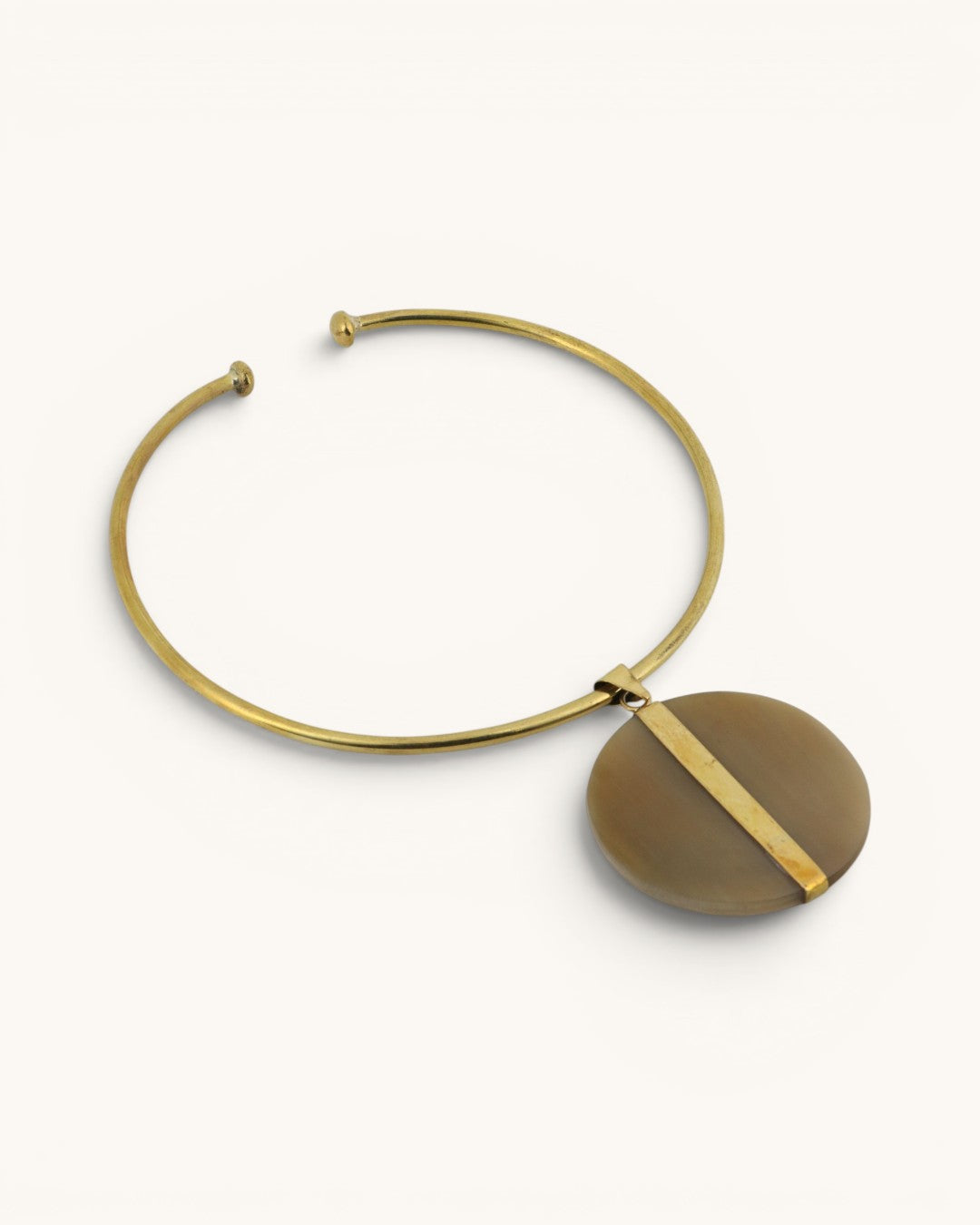 Brass collar choker necklace with Ankole horn disc pendant on white background, angled side view revealing the darker olive reverse face
