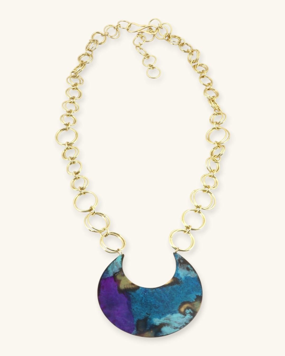 Hand-patinated brass crescent pendant necklace full view on white background showing complete gold ring chain and adjustable clasp