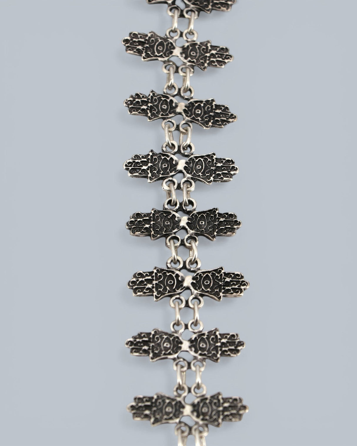 Cultural Elements antique silver tone lariat necklace with ornate Hamsa pendant and repeating links.