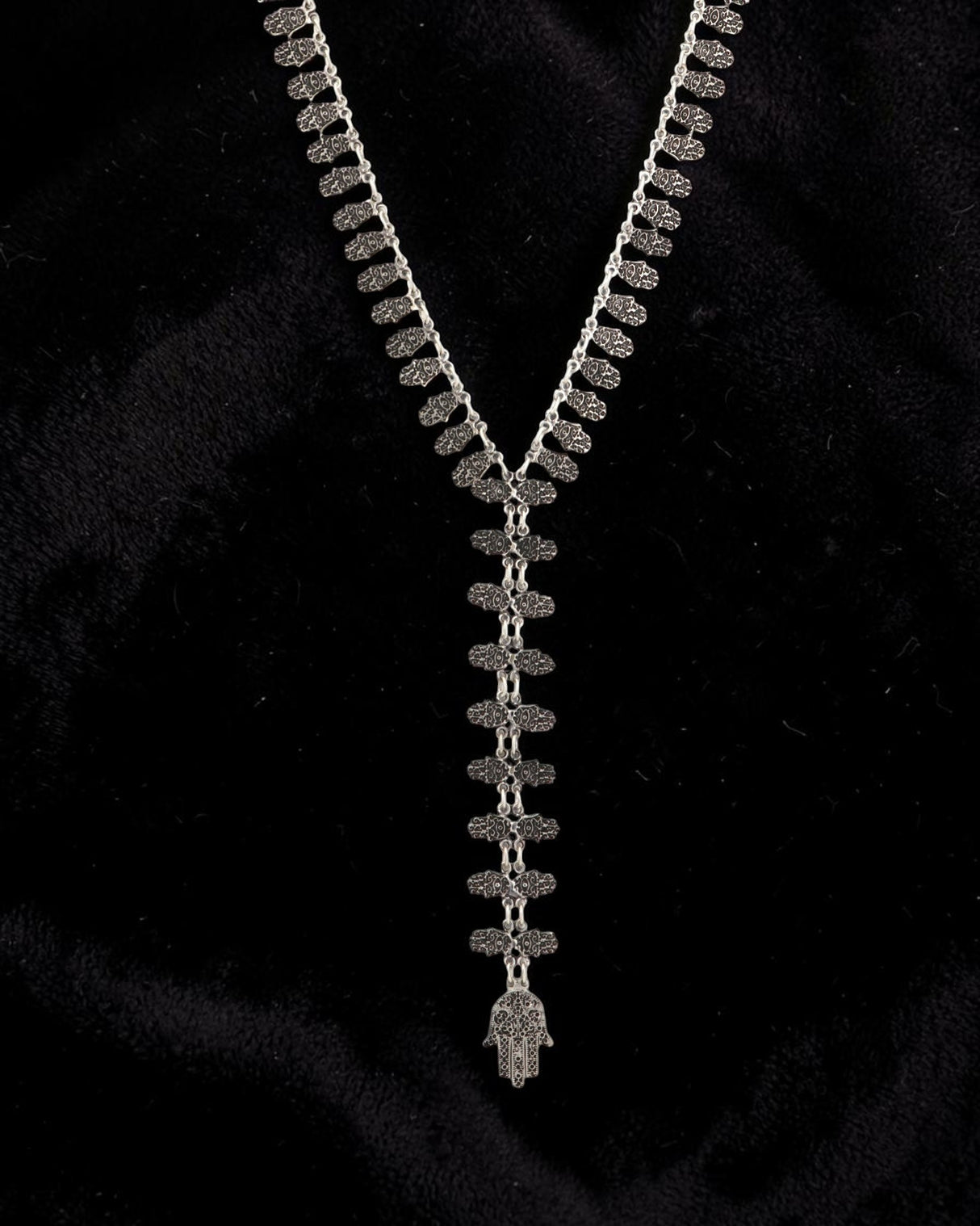 Cultural Elements antique silver tone lariat necklace with ornate Hamsa pendant and repeating links.