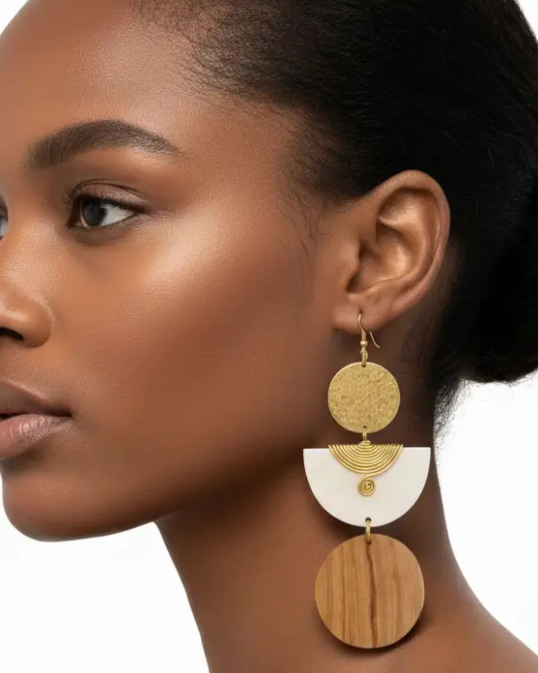 Kazuri brass and wood statement earrings worn on a model's ear, side profile showing full three-tiered drop length against white background