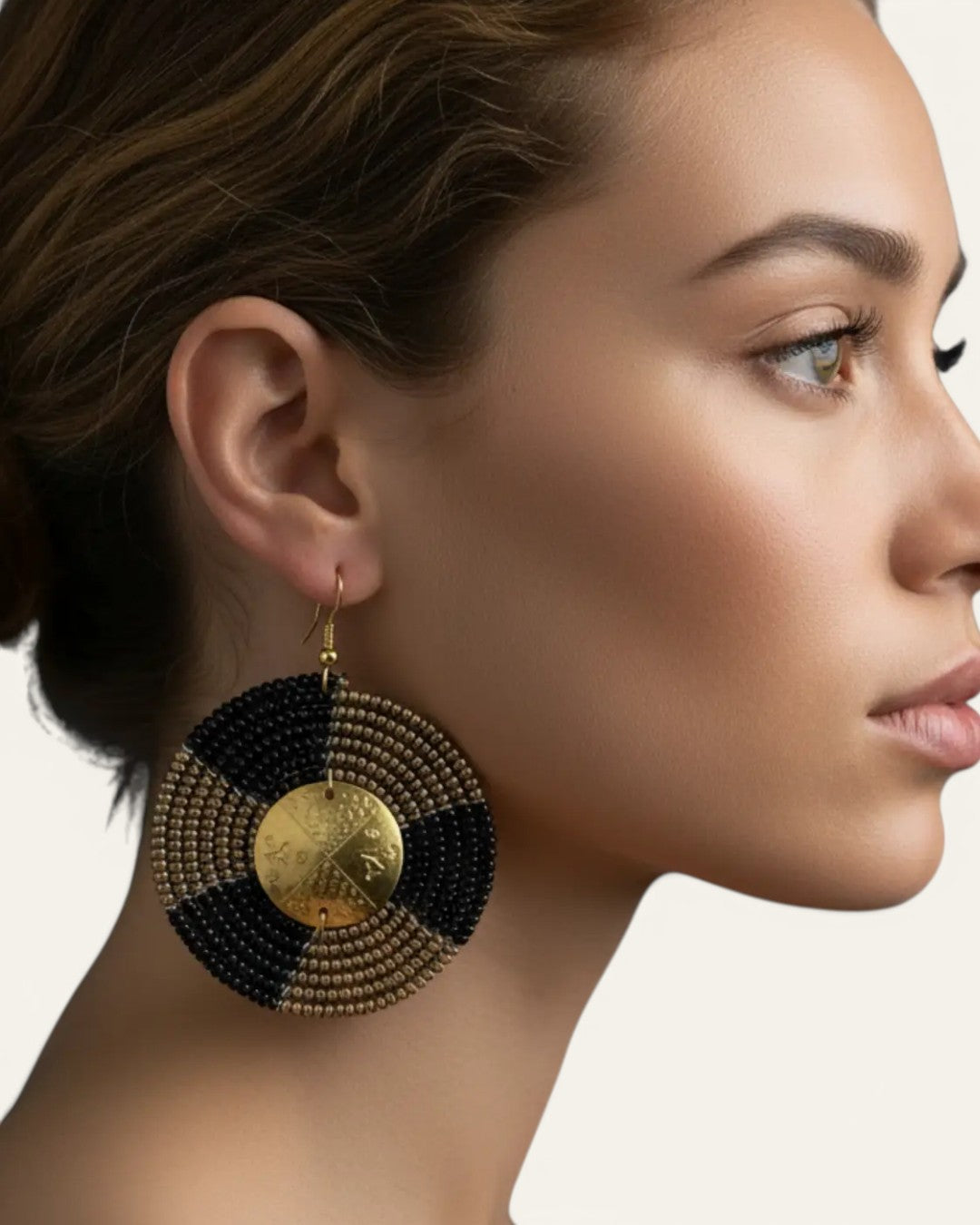 Kenyan hand-beaded circle earring on model in side profile view, showing full scale of beaded disc with engraved brass shilling coin