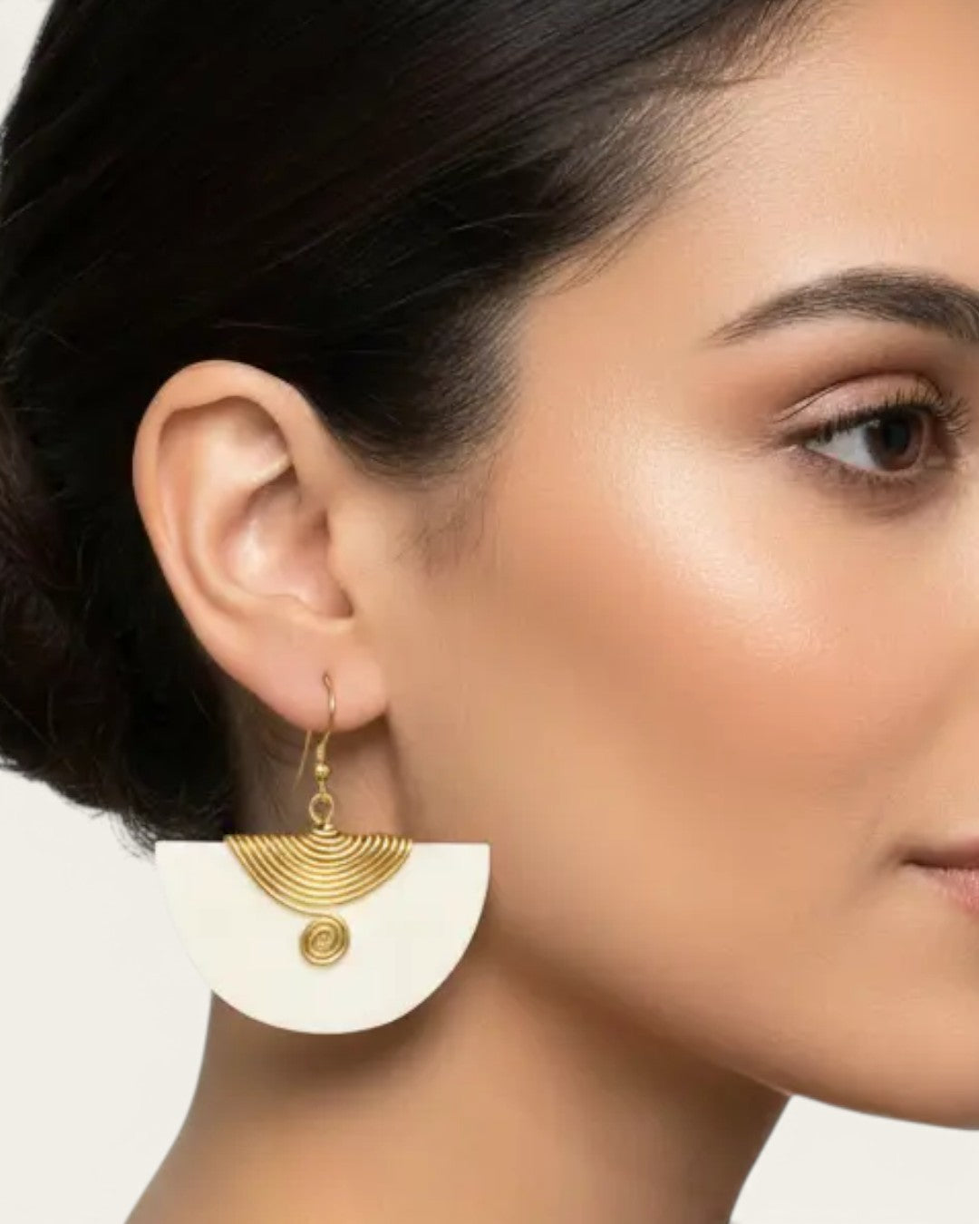 Kenyan bone and brass half-moon fan earring worn on model, side profile view showing drop length and brass wire fan design