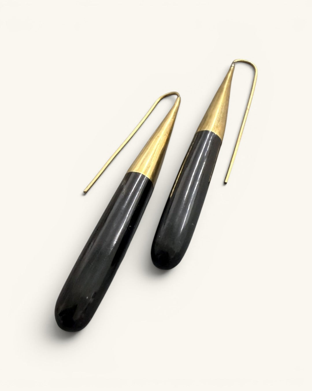 Kanai Kenyan horn and brass threader earrings at a diagonal angle highlighting polished horn texture and brass cone cap detail