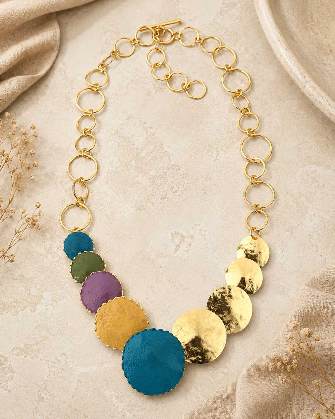 Close-up detail of hand-forged patina brass disc necklace highlighting hammered disc texture and aged brass patina finish