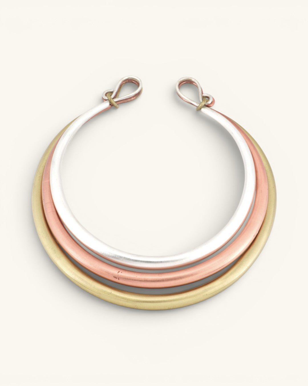 Tri-Tone Brass Collar Necklace front view on white background, three concentric silver, copper, and brass rings with hook clasps at top