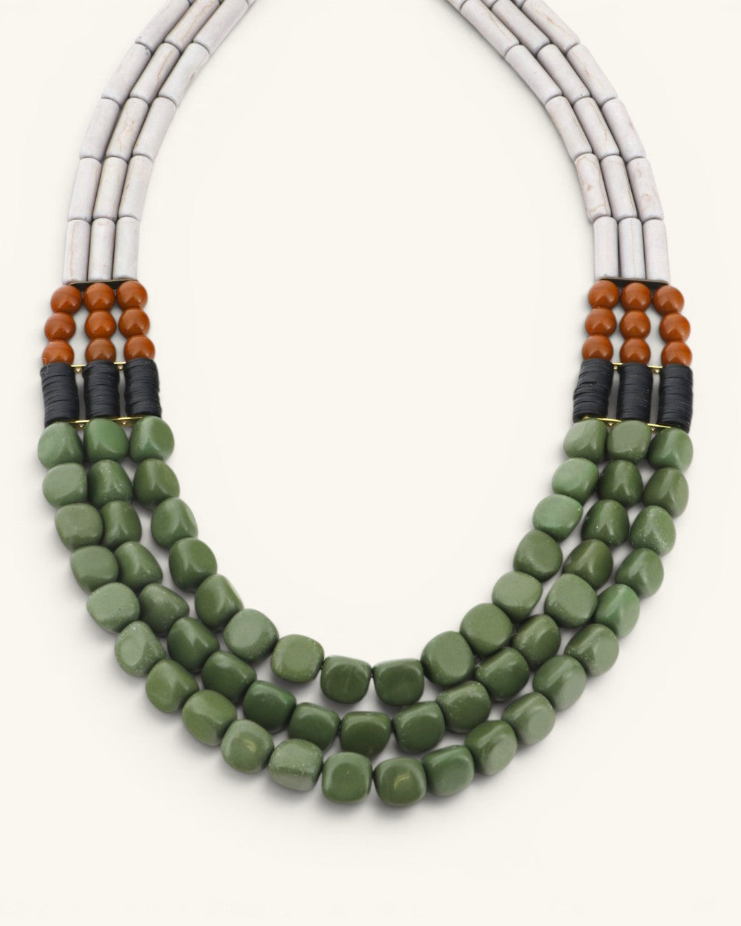 Close detail of triple strand serpentine and vulcanite necklace showing green tumbled beads, brown round bead accents and black disc spacers