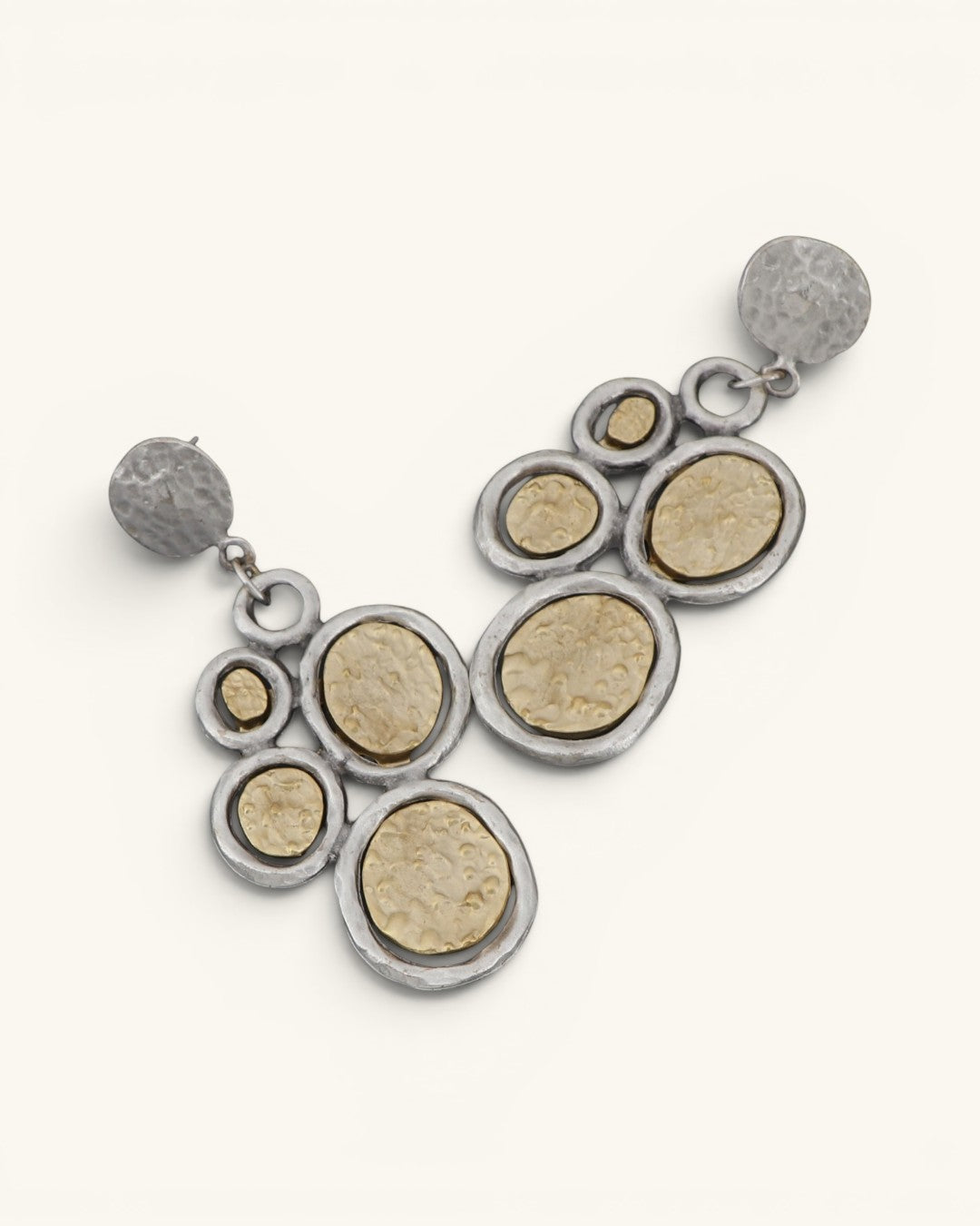 Turkish two-tone boho dangle earrings at diagonal angle showing hammered gold disc texture and silver ring frames