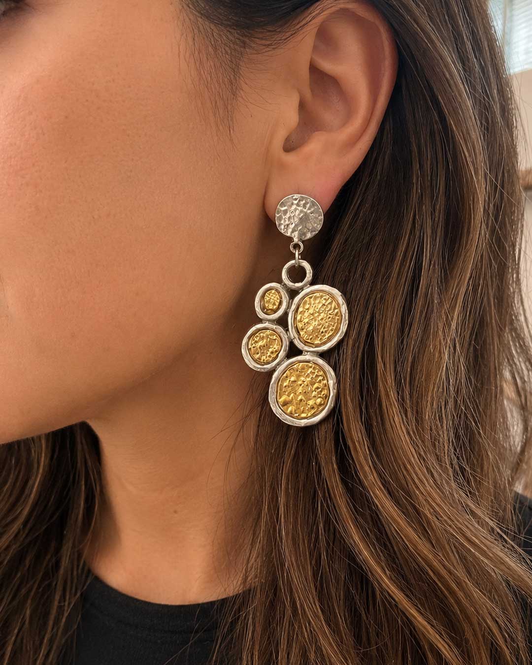 Turkish two-tone boho dangle earrings worn on model's ear, side profile showing hammered gold and silver disc detail