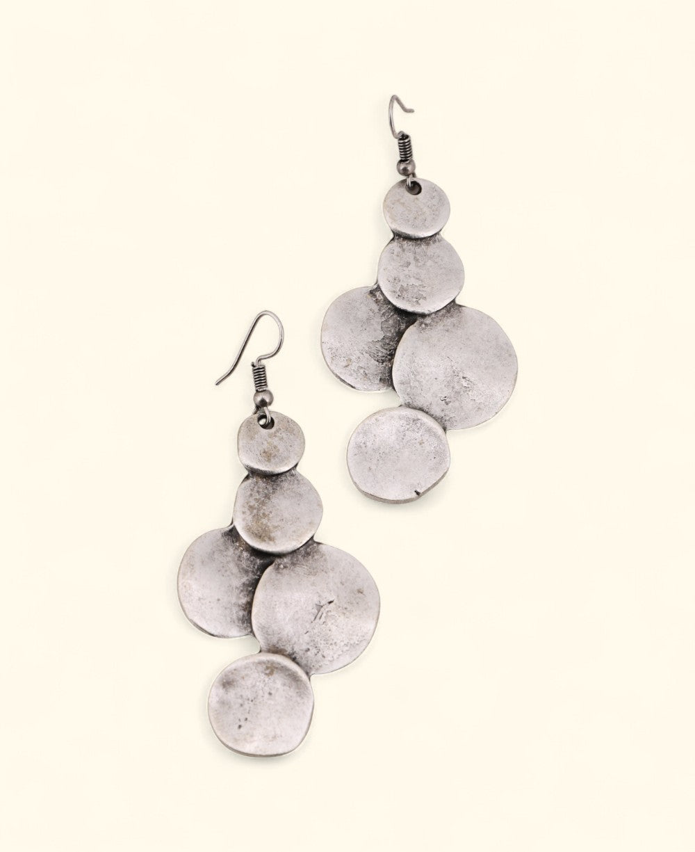Silver-plated disc drop earrings on neutral background