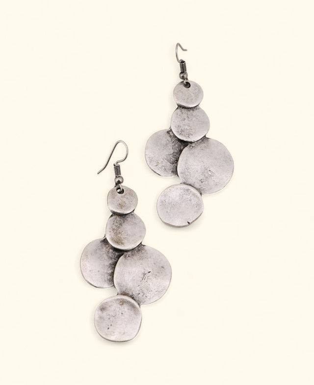 Silver-plated disc drop earrings on neutral background