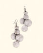 Silver-plated disc drop earrings on neutral background