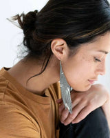 Woman wearing a silver earring with a blurred background