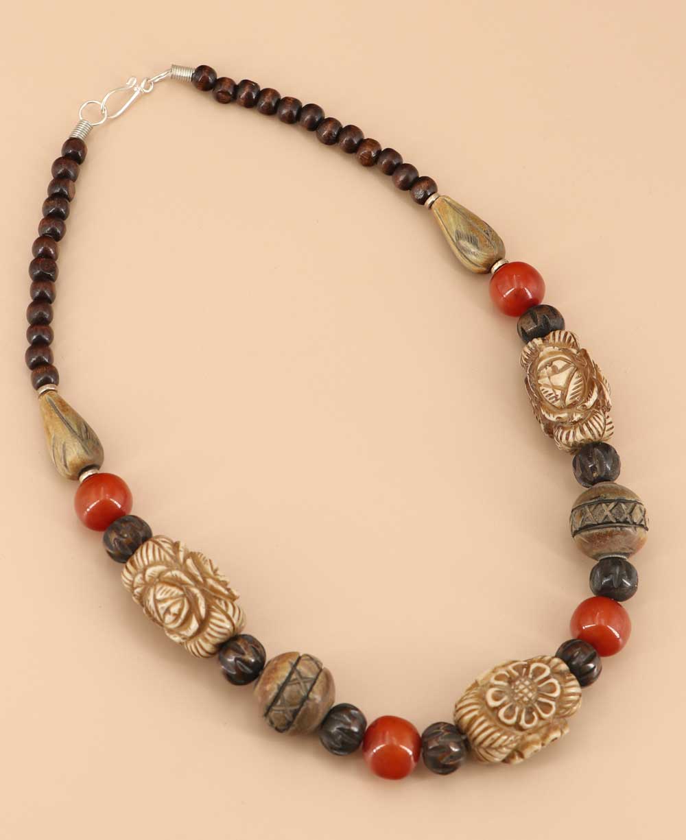 Handcrafted necklace with carved beads and red accents