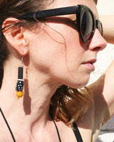 Black and white dotted earrings with yellow accent bead