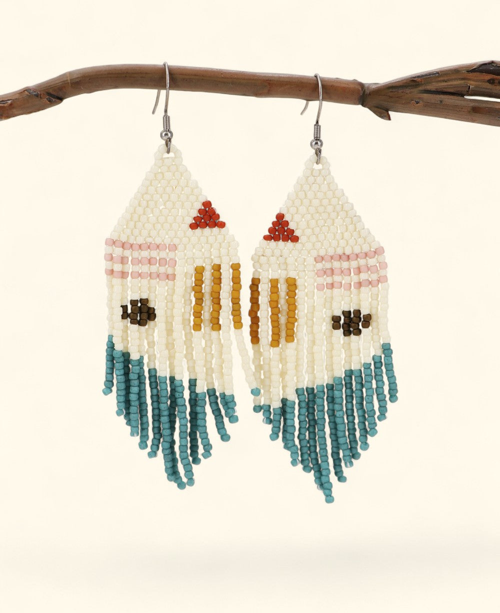 Pair of beaded earrings with colorful patterns hanging from a branch.