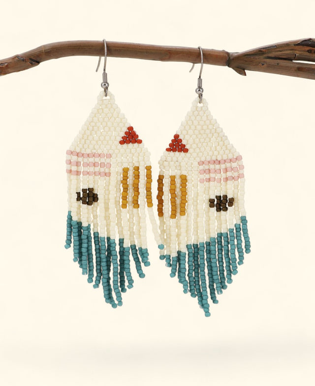 Pair of beaded earrings with colorful patterns hanging from a branch.