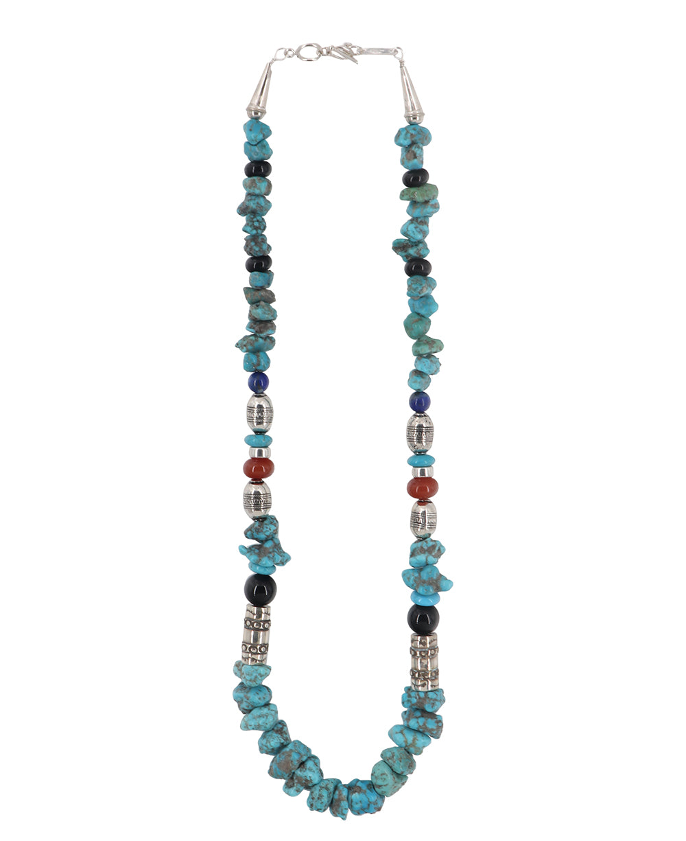 Close-up of the intricate sterling silver barrel clasp, tumbled turquoise stones, and vibrant coral and onyx beads