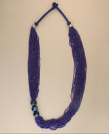 Multi-strand blue glass bead necklace with ceramic accents.