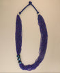 Multi-strand blue glass bead necklace with ceramic accents.