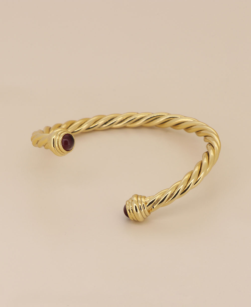 Close-up view of the intricate twisted rope design and dual stones on the gold-plated bracelet