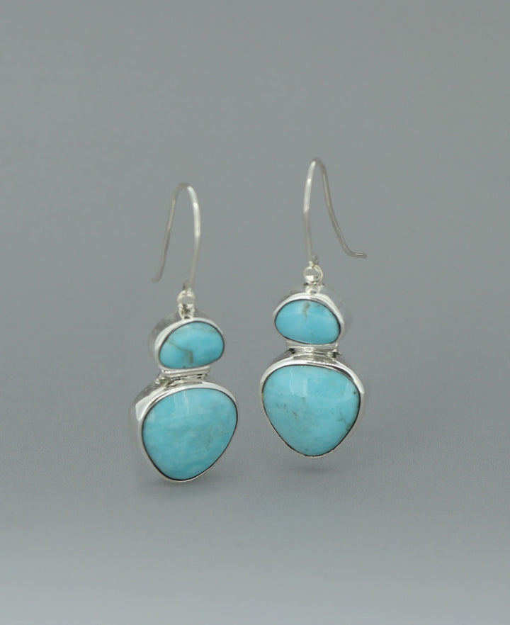 Full view of the sterling silver Genuine Turquoise dangling earrings against a light background, emphasizing the vibrant Kingman turquoise