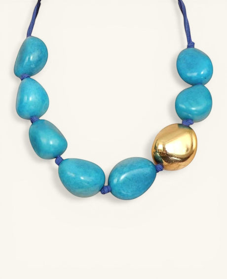 Cultural Elements blue tagua nut necklace with 24K gold plated pod and blue suede cord.
