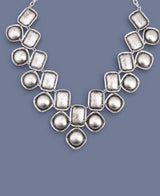 Silver necklace with geometric design on a blue background