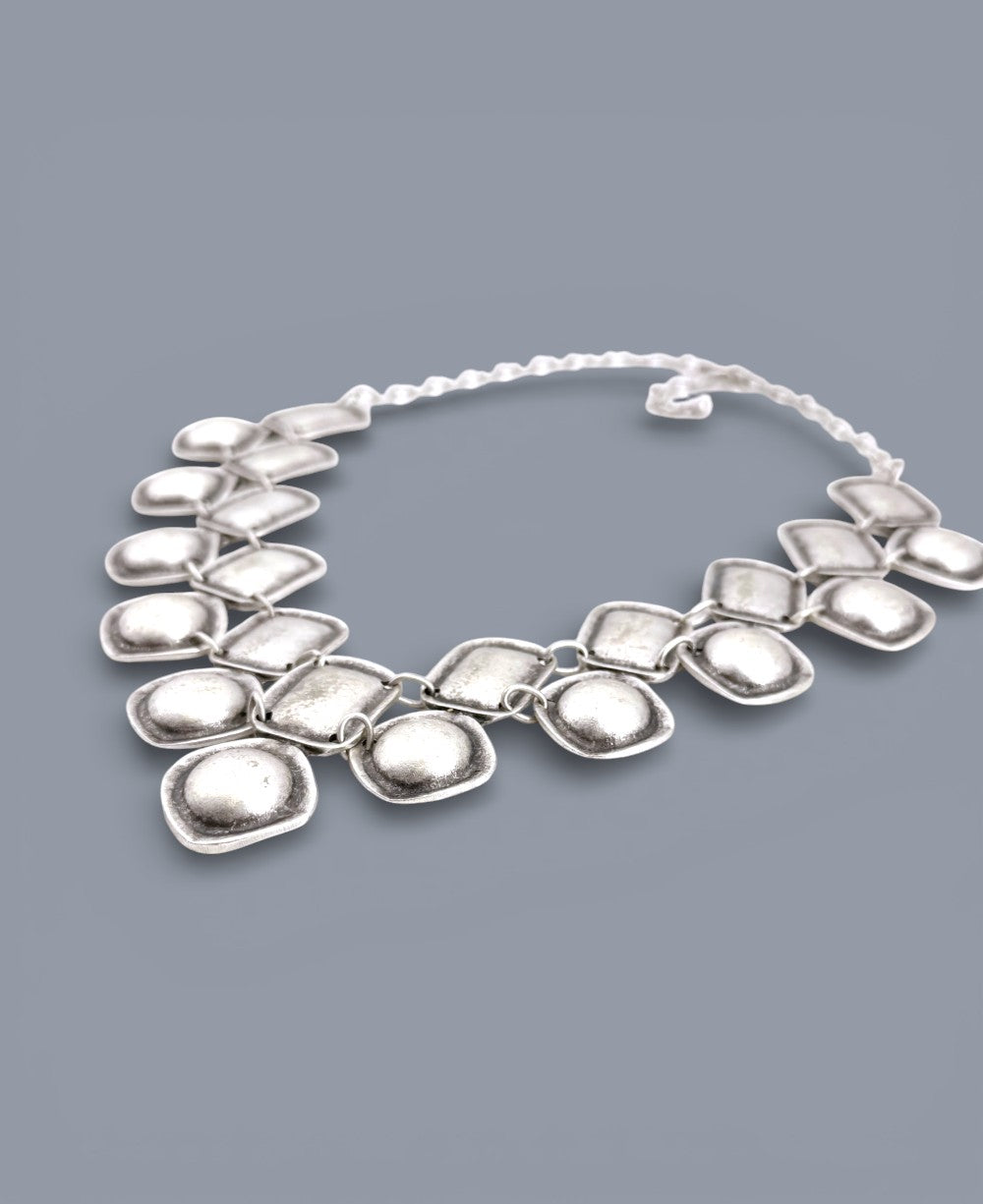 Silver necklace on a gray background