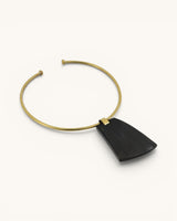 Ankole horn pendant brass choker necklace angled side view on white background, showing depth of horn pendant and open collar ends