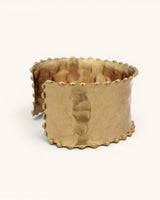 Beaded edge hand-hammered brass cuff bracelet at a three-quarter angle revealing the wide hammered face and beaded side edges