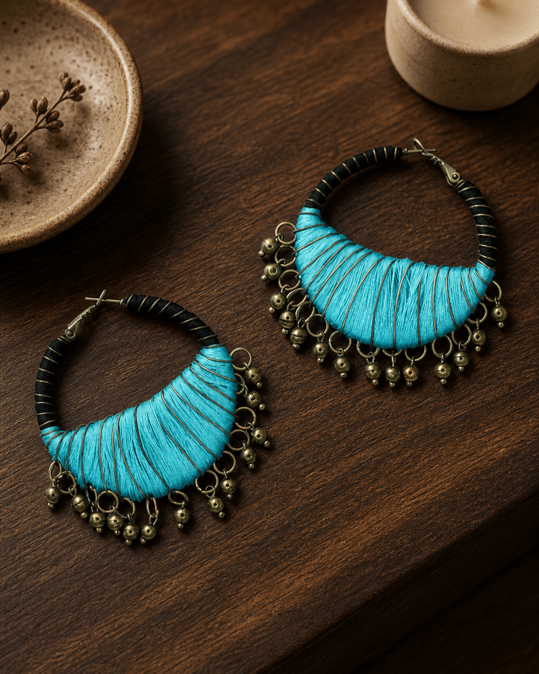 Black and Aqua Handcrafted Thread-Wrapped Hoop Earrings — earrings, editorial wood console lifestyle photo