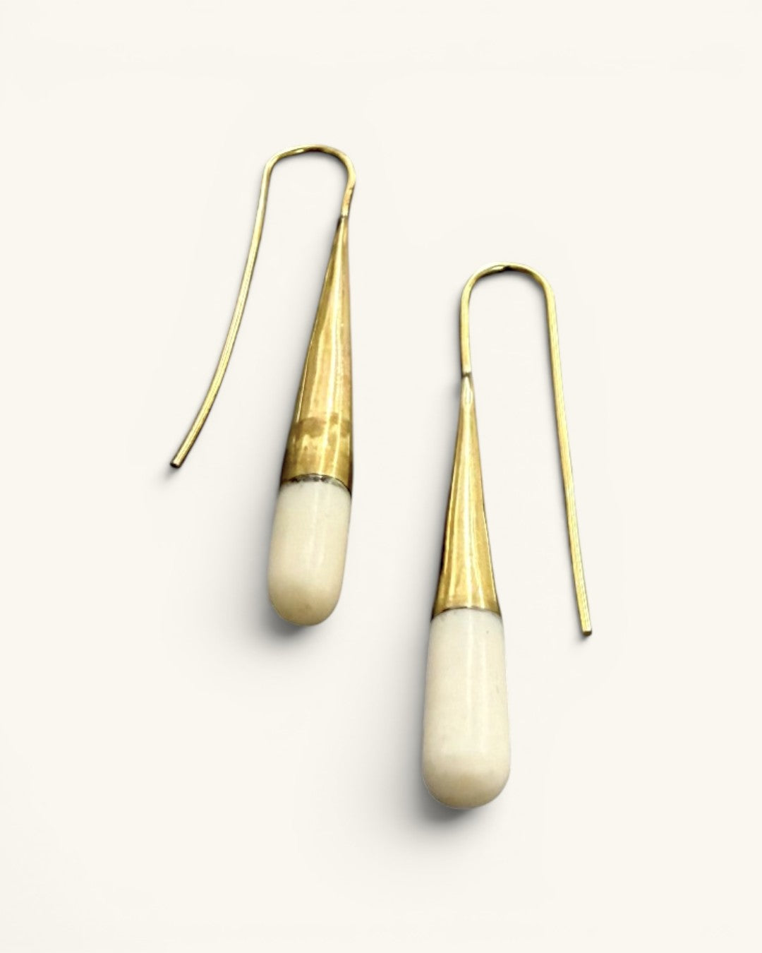 Tosha bone and brass threader drop earrings on white background, angled view highlighting elongated bone drop tips and threader wire