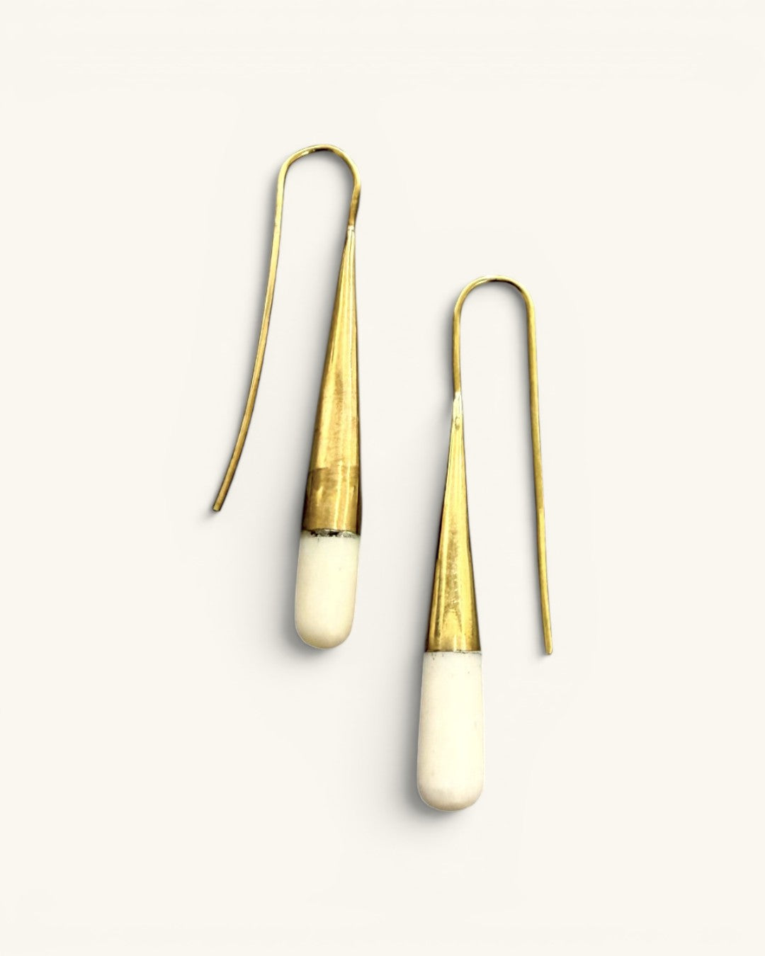 Tosha bone and brass threader drop earrings pair on white background, showing brass cone body and rounded bone tips