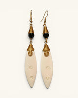 Hand-coiled brass and carved bone drop earrings with black bead, front view on white background showing both pieces