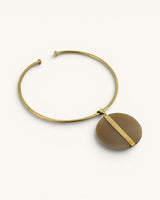 Brass collar choker necklace with Ankole horn disc pendant on white background, angled side view revealing the darker olive reverse face
