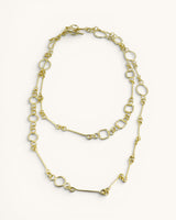 Brass link geometry long wrap necklace flat lay on white background with toggle clasp visible and mixed link pattern