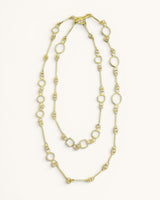 Handmade brass link geometry long wrap necklace laid flat on white background, showing circular and square links in double loop